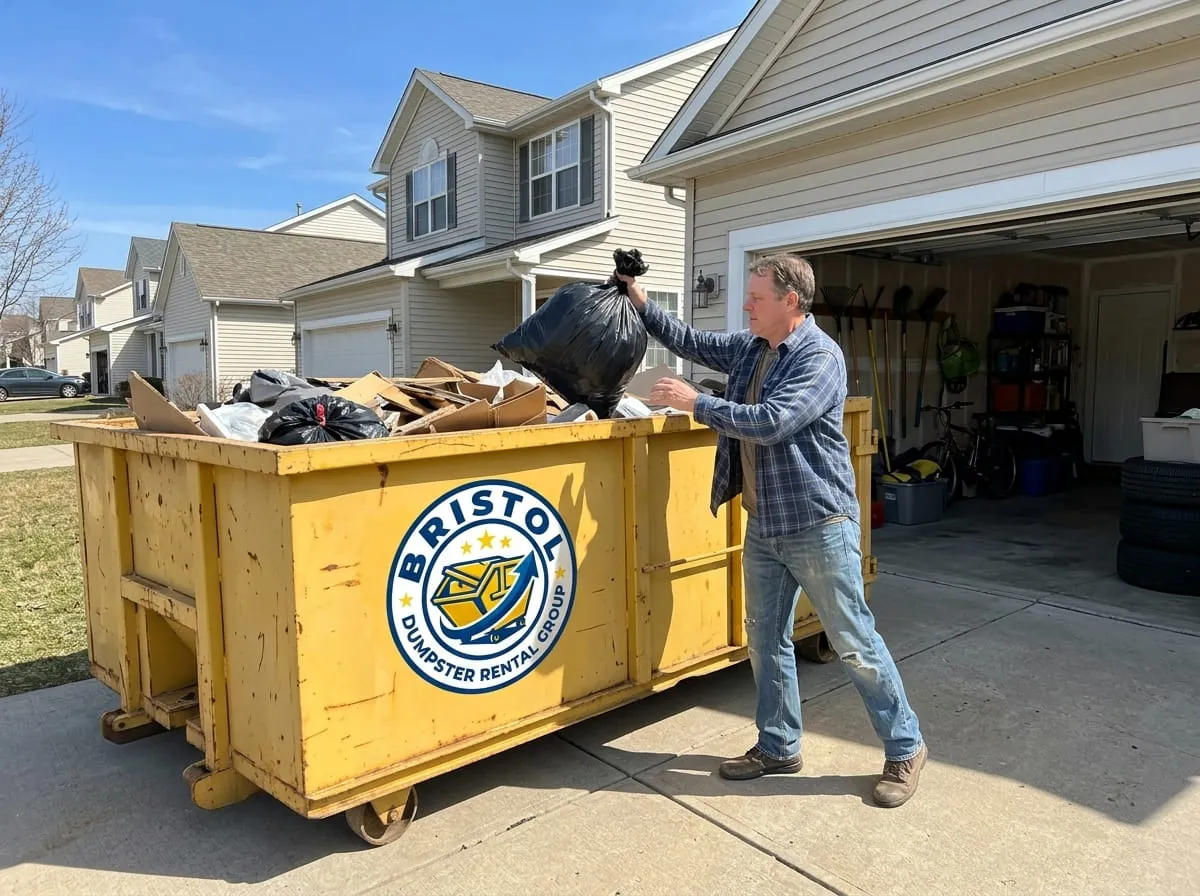 Homeowner loading household junk into a roll-off dumpster in Bristol, Connecticut Homeowner loading household junk into a roll-off dumpster in Bristol, Connecticut